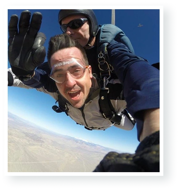 Tandem skydiver waving